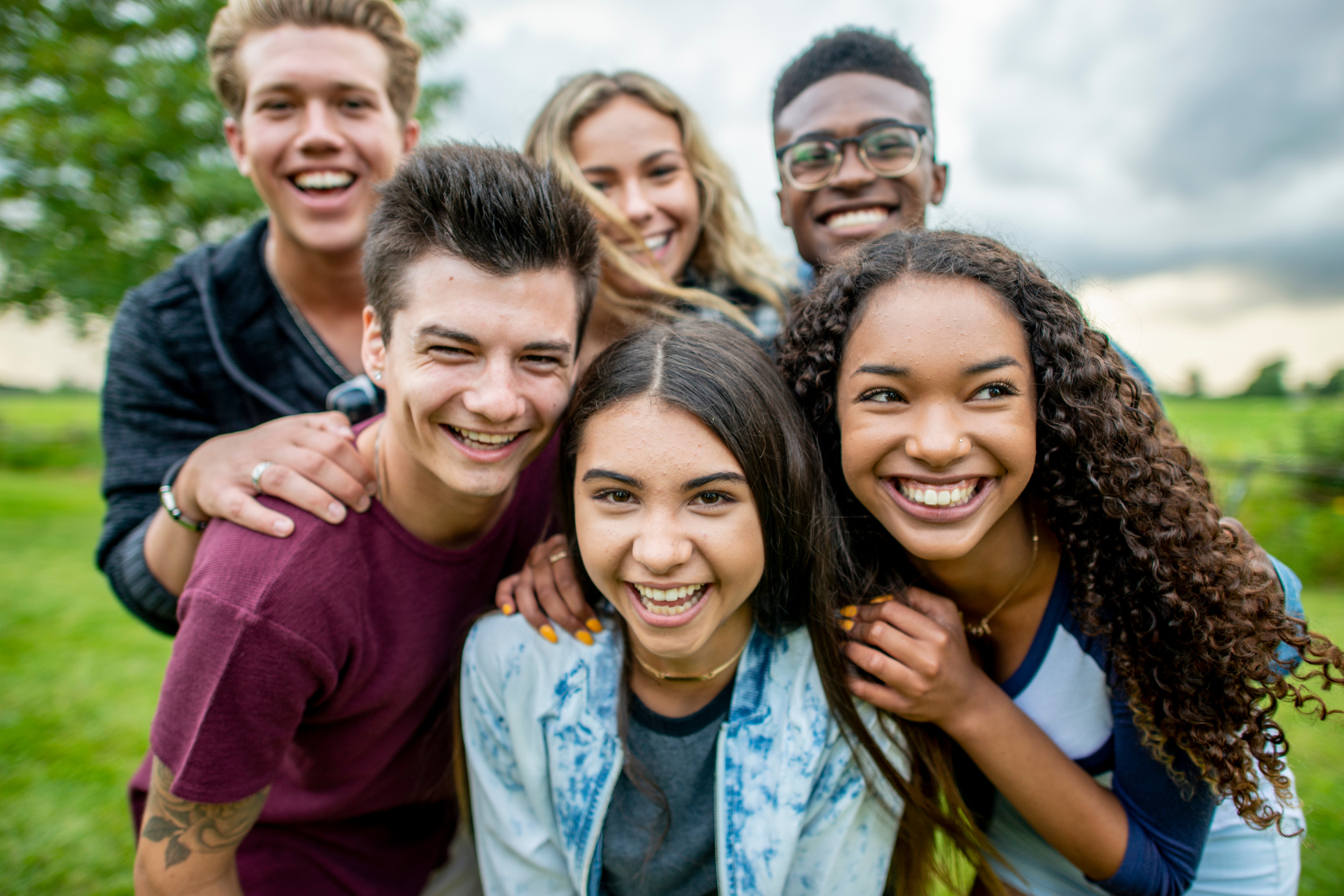 Grupo de 6 adolescentes sonriendo afuera