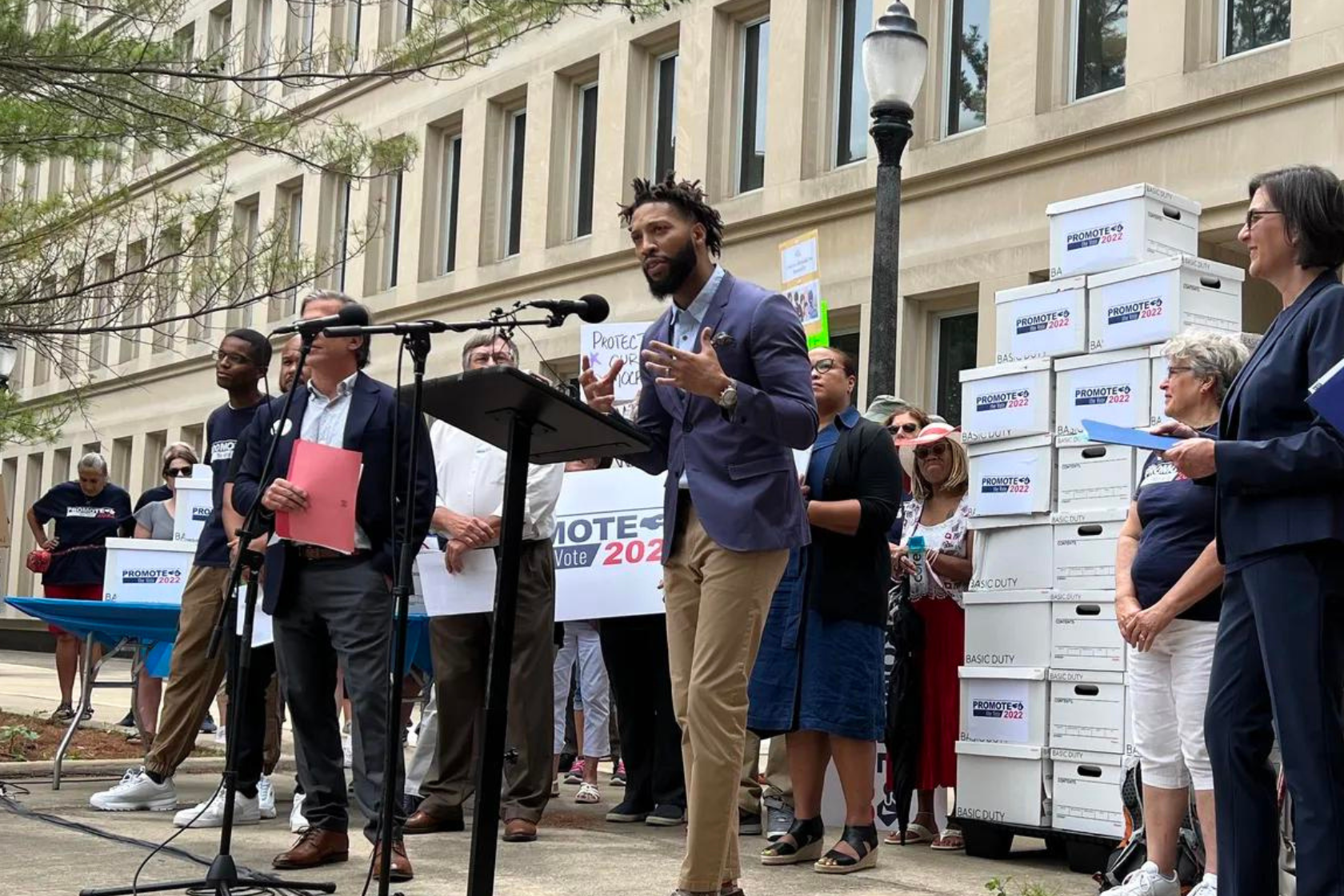 Фотография пресс-конференции, на которой организация Promote the Vote сдала все подписанные петиции по предложению 2-2022.